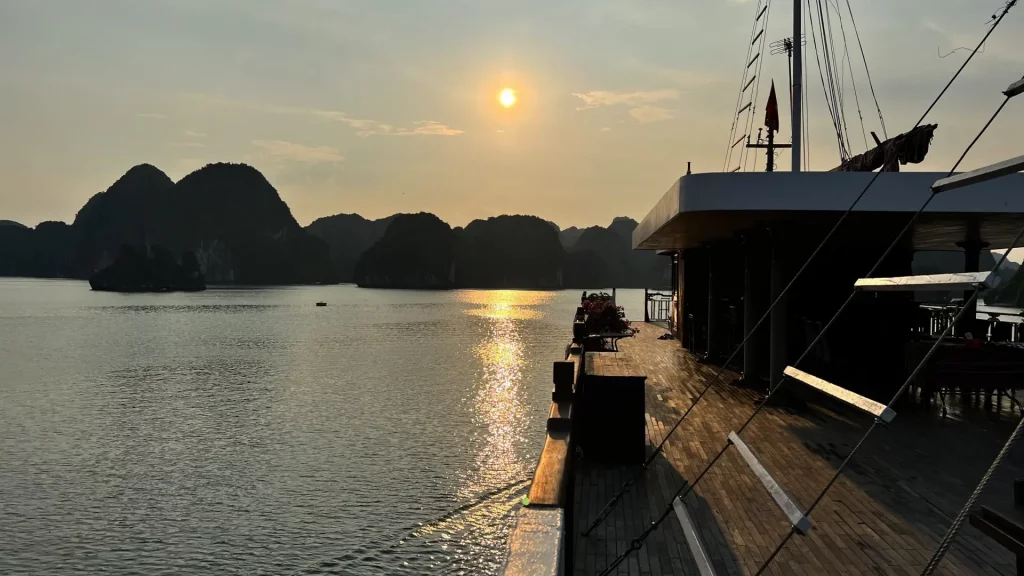 Vistas desde un crucero en la bahía de Lan Ha, Cat Ba, Vietnam, al atardecer con formaciones rocosas y reflejos en el agua.