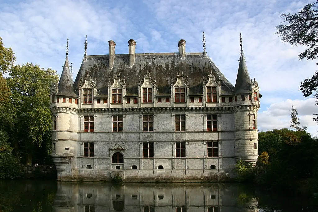 Fachada del Château d'Azay-le-Rideau reflejada en el agua, con su elegante arquitectura renacentista rodeada de vegetación en el Valle del Loira, Francia.