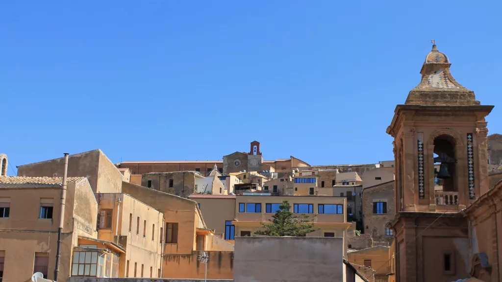 Casco histórico de Agrigento con arquitectura tradicional y una iglesia con campanario.