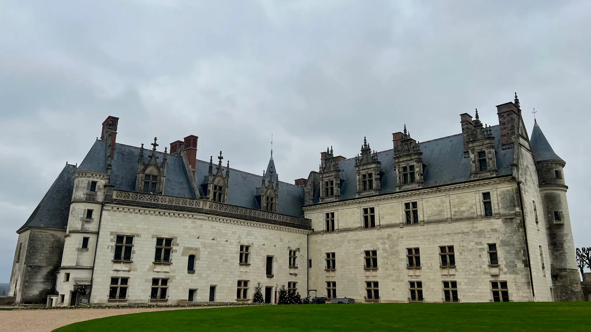 Fachada del castillo de Amboise en un día nublado, con su arquitectura renacentista y un césped verde en el Valle del Loira, Francia.