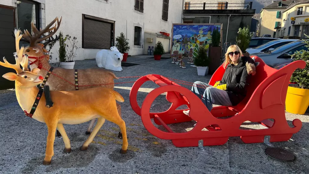 Decoración navideña en Laruns, Pirineo Francés, con un trineo rojo y renos
