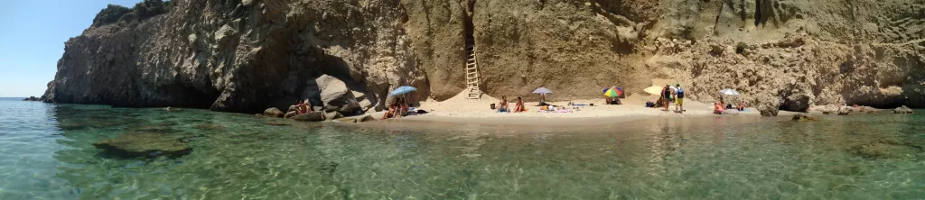 Vista panorámica de la Playa Tsigrado en Milos con aguas turquesas y acantilados impresionantes.