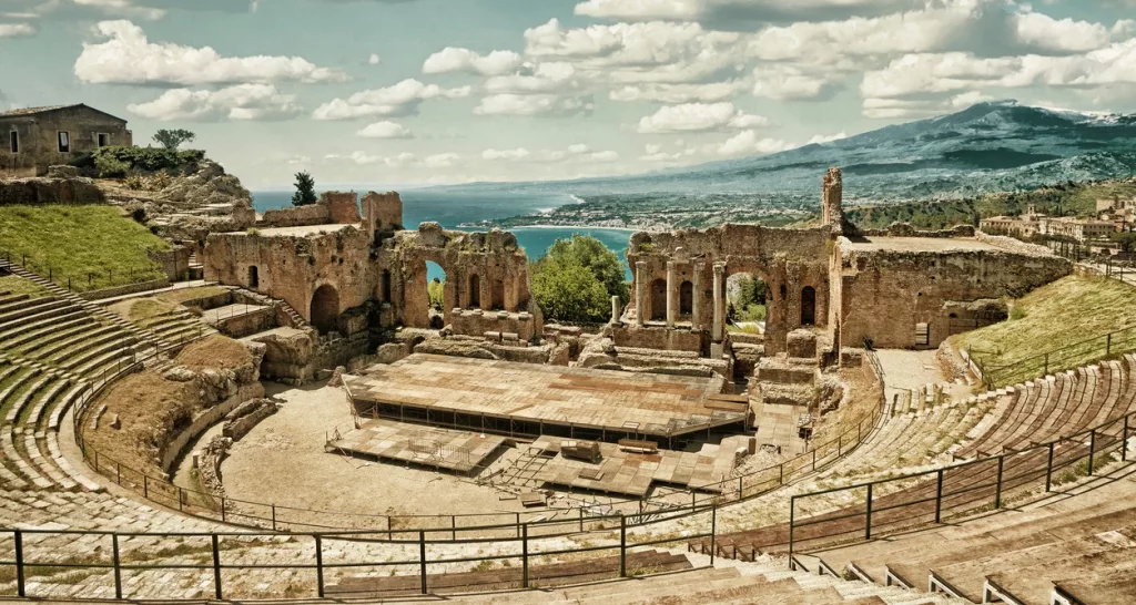 Vista del Teatro Greco de Taormina con el Etna al fondo, una postal icónica de Sicilia.
