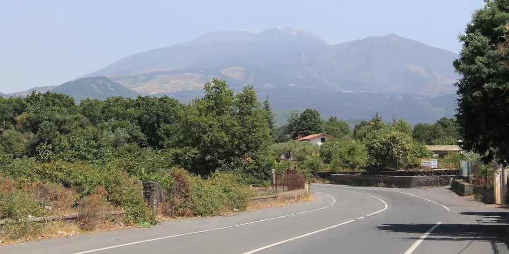 Vista del volcán Etna desde la carretera, con su silueta destacada sobre el paisaje de Sicilia.