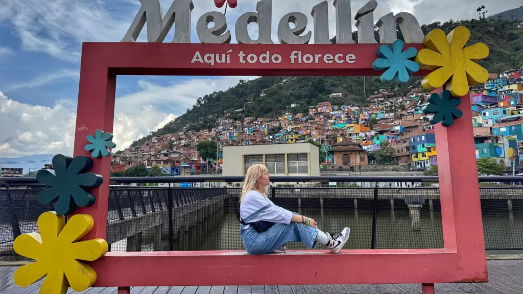 Ana en Medellín junto al icónico marco 'Aquí todo florece'