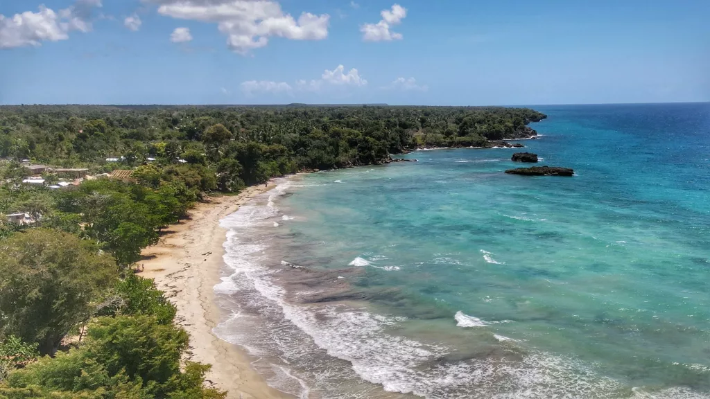 Playa Blanca en Boca de Yuma con aguas turquesas y vegetación caribeña en un día soleado