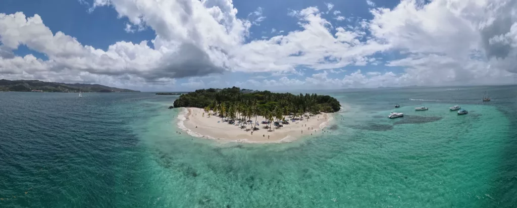 Vista aérea de Cayo Levantado en Samaná con aguas turquesas, palmeras y barquitos en la costa