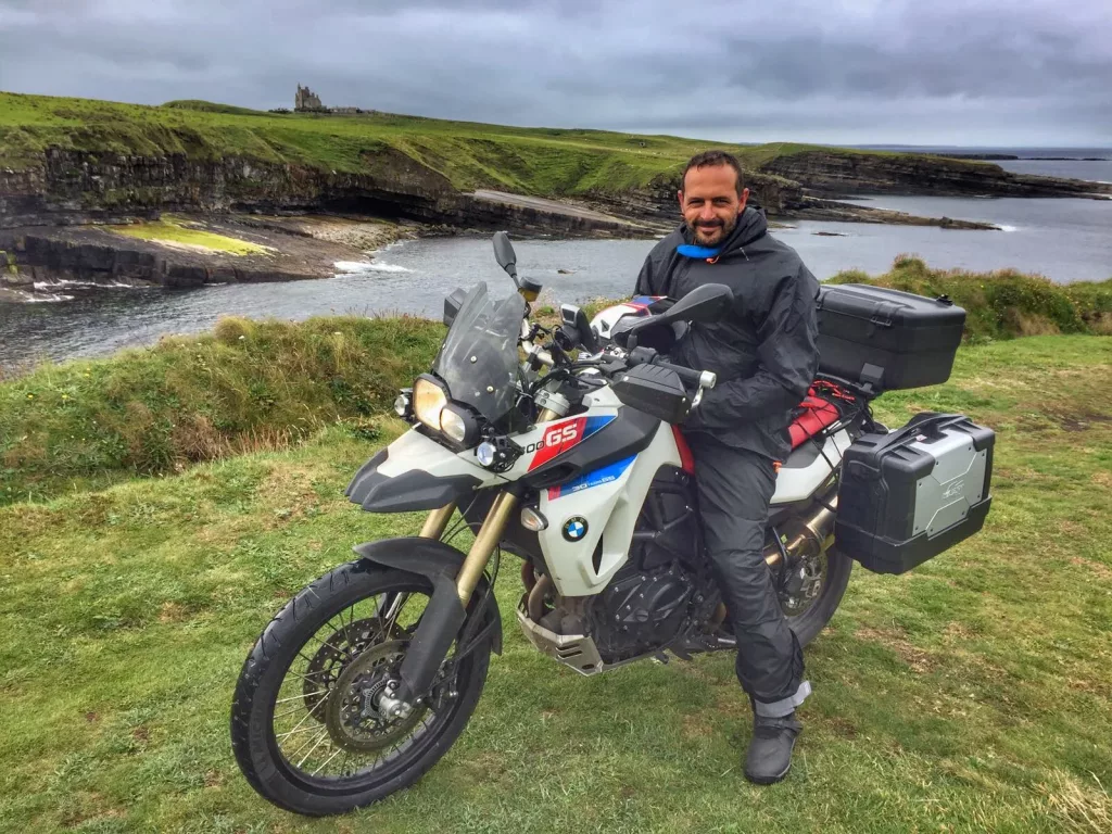 Ruta en moto por la costa de Irlanda con castillo al fondo