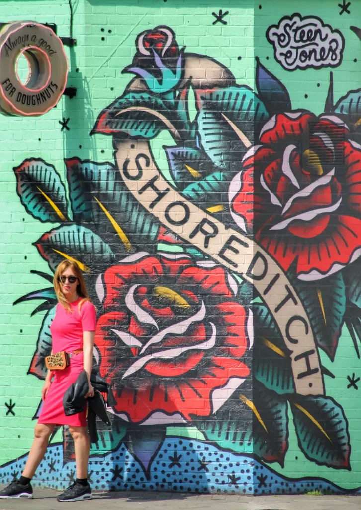  Vibrante mural de Shoreditch en Londres con rosas rojas y verdes que llenan de vida el barrio