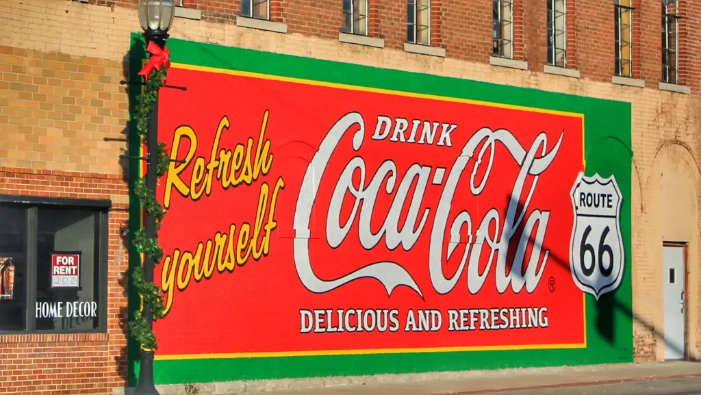 Mural vintage de Coca-Cola en la Ruta 66 de Kansas con la icónica señal de la carretera