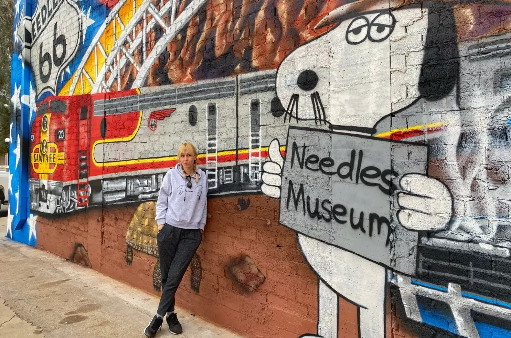 Ana de Two on Trip junto al mural del Needles Museum en la Ruta 66