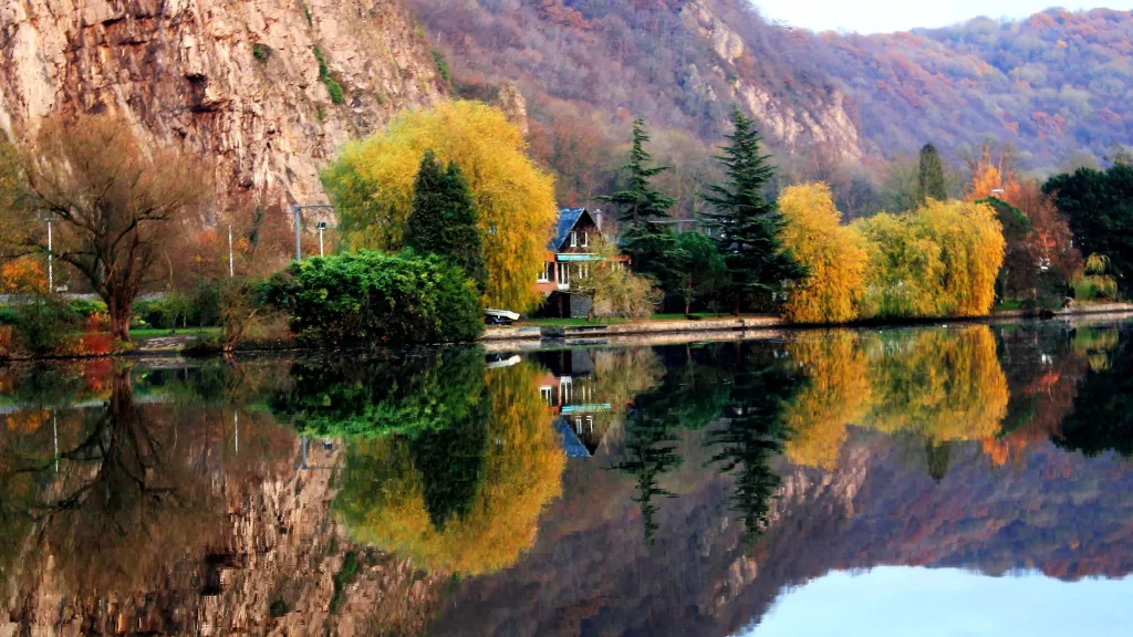 Río Mosa en Bélgica, reflejo de los árboles y colinas en el agua.