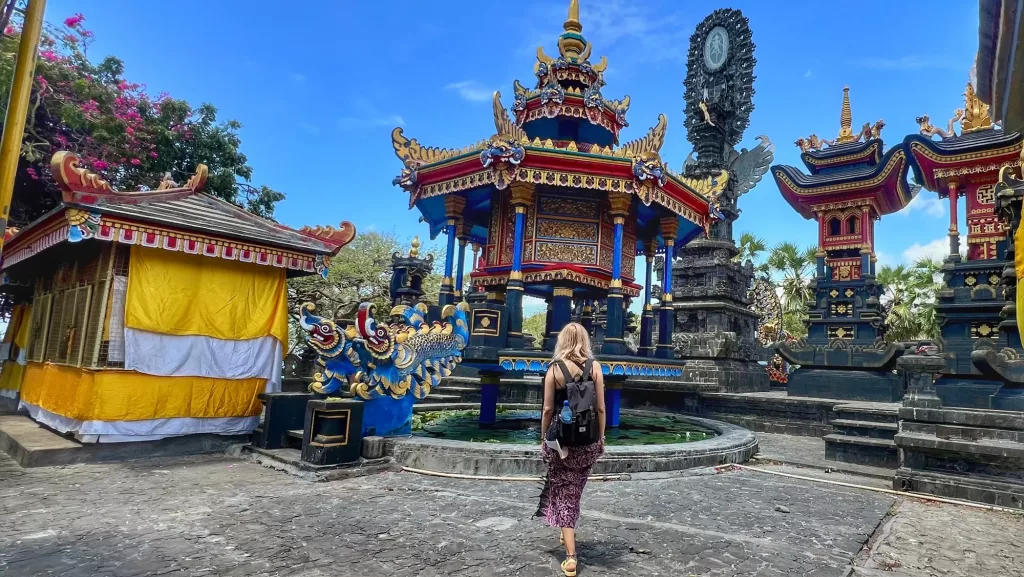 Ana explorando el templo Pura Pabean en Bali, con su arquitectura colorida y decoraciones únicas.
