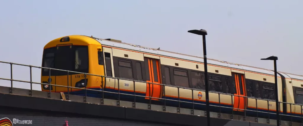 Transporte en Londres: tren del Overground en marcha sobre un puente