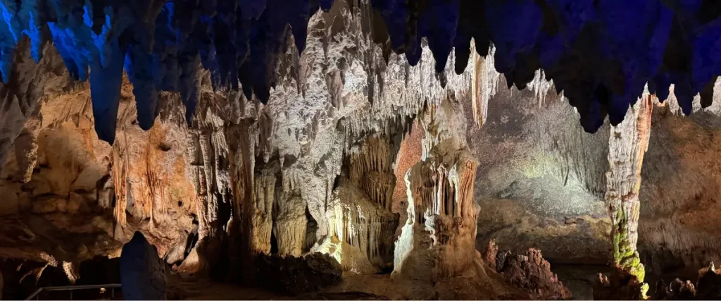 Interior iluminado de la Cueva de las Maravillas en República Dominicana con estalactitas y estalagmitas
